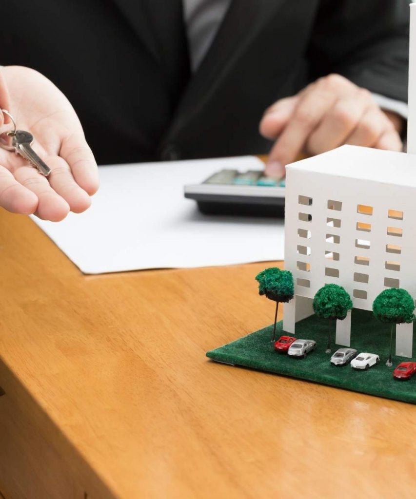 A happy couple holding house keys, symbolising successful Executive Condominium (EC) owners in Singapore after completing their Minimum Occupation Period (MOP) and moving toward their next home or investment.